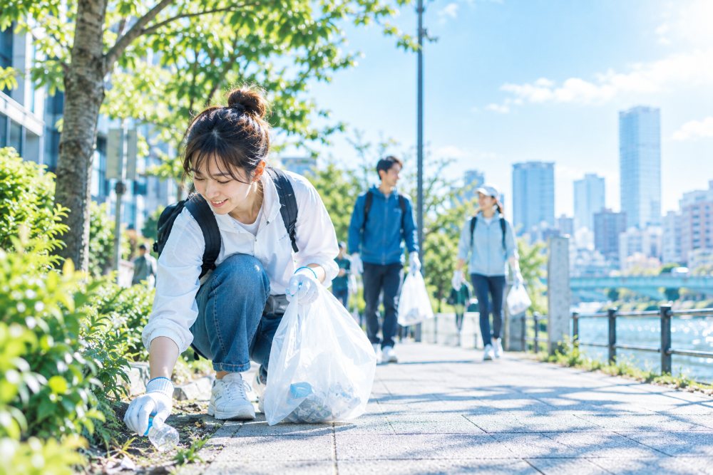 歩道の脇で、街の小さなごみを拾う一人